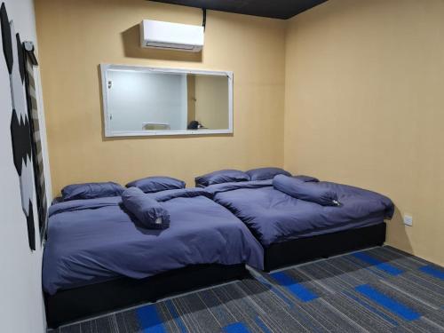 - une chambre avec un grand lit et des oreillers bleus dans l'établissement Ayden Hostel Airport Transit - KLIA, à Sepang