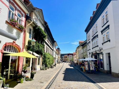 eine leere Straße mit Gebäuden und einem Regenschirm in der Unterkunft City Appartements Arnstadt in Arnstadt