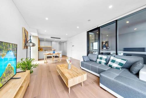 シドニーにあるAdorable 2B Apt near Macquarie Uniのリビングルーム(ソファ、テーブル付)