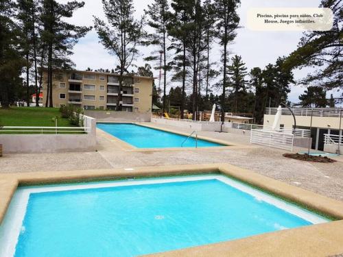 a large blue pool with a building in the background at Depto hermoso El Tabo in El Tabo