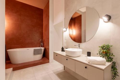 a bathroom with a tub and a sink and a mirror at Luxurious Minimalist Residence with Sauna by Prestige Homes in Budapest