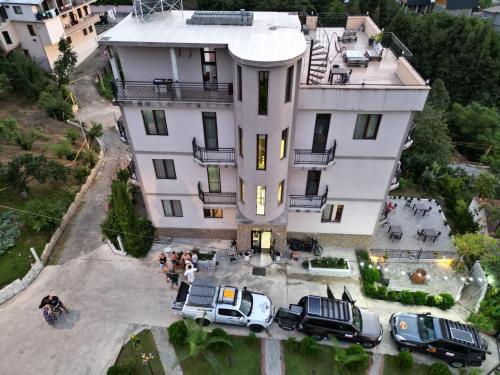 a white house with cars parked in front of it at Green Yard Hotel in Batumi