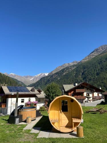 ein Holzboot auf dem Rasen vor den Häusern in der Unterkunft Chalet Bucaneve in Santa Caterina Valfurva