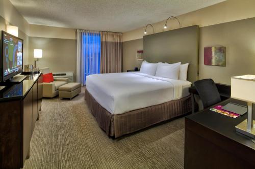 um quarto de hotel com uma cama grande e uma televisão de ecrã plano em Crowne Plaza - Chicago West Loop, an IHG Hotel em Chicago