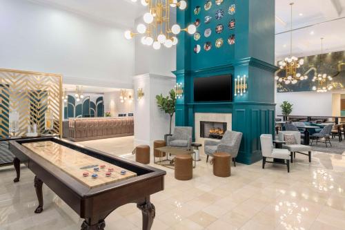 Homewood Suites by Hilton New Orleans في نيو أورلينز: لوبي مع طاولة بلياردو ومدفأة