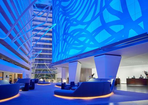 een lobby met blauwe stoelen en een blauw plafond bij Conrad New York Downtown in New York