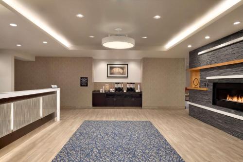 Hampton Inn & Suites Rosemont Chicago O'Hare في روزمونت: لوبي فيه موقد وغرفة انتظار