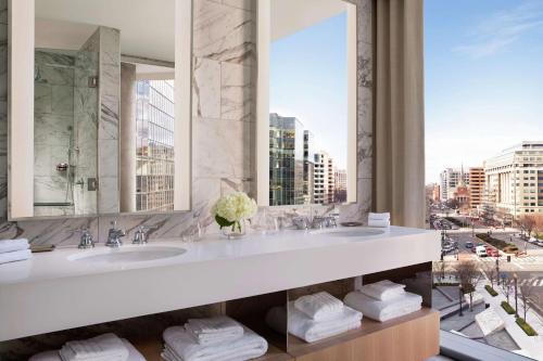 a bathroom with two sinks and a view of a city at Conrad Washington DC in Washington