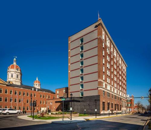 un edificio alto de ladrillo en una calle con una intersección callejera en The Yorktowne Hotel, Tapestry Collection by Hilton, en York