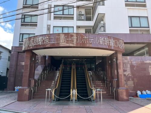 ein Gebäude mit einer Wendeltreppe vor einem Gebäude in der Unterkunft Hiroshima Ekimae Universal Hotel in Hiroshima