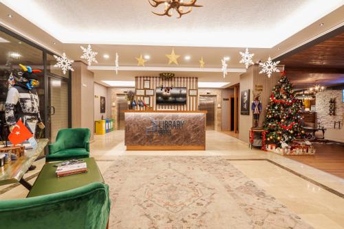 een woonkamer met een kerstboom en een lobby bij Library Hotel Erciyes in Kayseri