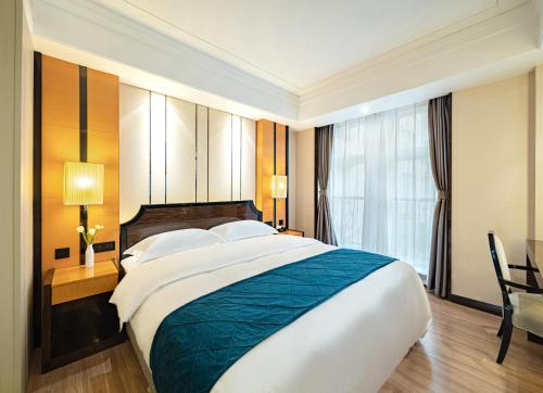 - une grande chambre avec un grand lit et une fenêtre dans l'établissement Evening Breeze Hotel 晚风酒店, à Chengdu