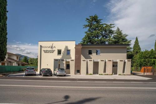 a building with two cars parked in a parking lot at Monolocale Moderno Valpolicella Verona - Agni in San Pietro in Cariano