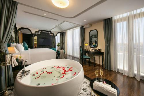 pokój hotelowy z wanną wypełnioną czerwonymi kwiatami w obiekcie Grand Sunrise Palace Hoi An w Hoi An