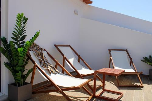 een groep stoelen in een kamer met een plant bij Casa dos Cucos in Ericeira