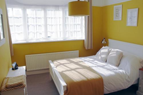 a bedroom with a white bed and a window at Charming 1800s Port Sunlight Worker's Cottage in Port Sunlight