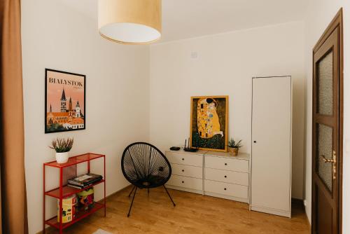 a white room with a chair and a dresser at Flathouse Apartment 2 Centrum in Białystok