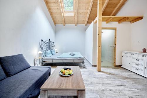 a living room with a couch and a bowl of fruit on a table at Apartmány Svatošské skály in Loket