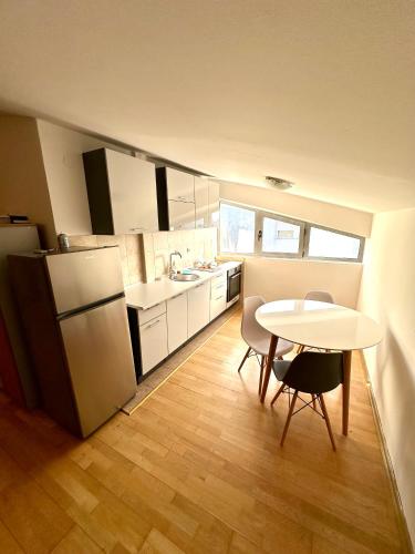 uma cozinha com uma mesa e uma mesa e cadeiras em Apartment Stex 3 em Podgorica