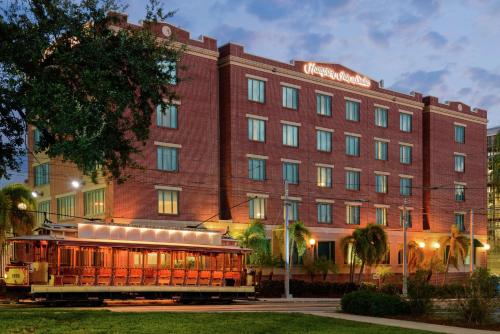 Hampton Inn & Suites Tampa Ybor City Downtown في تامبا: فندق فيه عربة امام مبنى