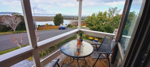 オークランドにあるAuckland Sea&SkyTower view Homestay with free Netflix, Parkingの通りの景色を望むバルコニー(テーブル、椅子付)