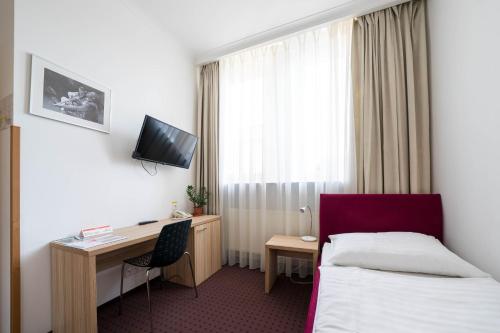 a hotel room with a bed and a desk at Mini Hotel Akord in Ostrava