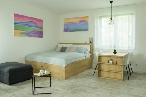 um quarto com uma cama, uma cadeira e uma mesa em Apartmán X28 em Mikulov