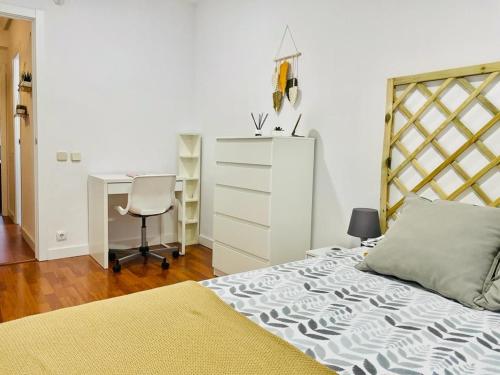 赫塔费Apartamento ABRIL en el Centro de Getafe的一间卧室配有一张床、一张桌子和一把椅子