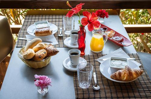 - une table avec petit-déjeuner composé de pain et de jus d'orange dans l'établissement Mare E Monti, à Porto Pollo