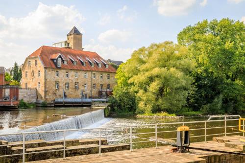 stary budynek obok rzeki z wodospadem w obiekcie CASCADA Rheine by Hackmann w mieście Rheine