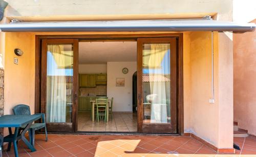 un patio con porte scorrevoli in vetro, tavolo e sedie. di Casa Faedda Residence Weber a La Maddalena