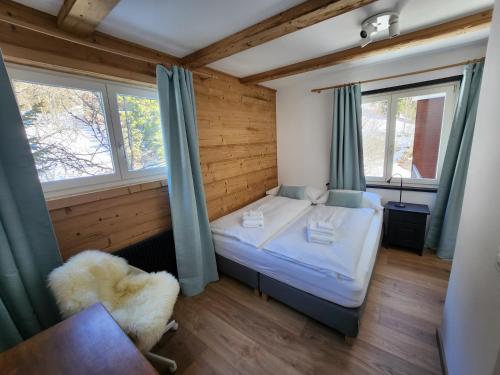 1 dormitorio pequeño con 1 cama y 2 ventanas en Hotel Bergsonne Rigi, en Rigi Kaltbad