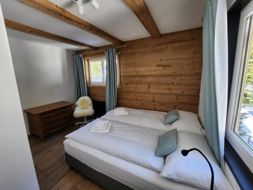 1 dormitorio con 1 cama en una habitación con paredes de madera en Hotel Bergsonne Rigi, en Rigi Kaltbad