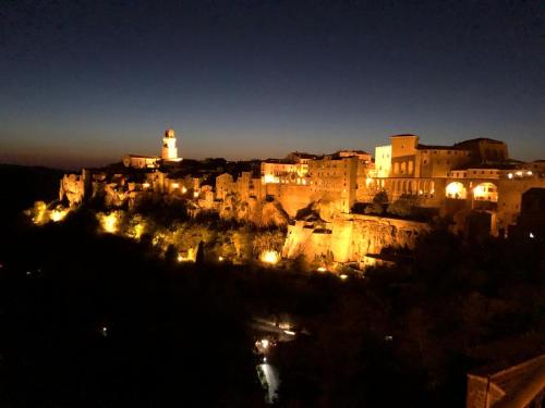 a view of a city at night with a lighthouse at Neoclassico by Tiziana Monaldi in Pitigliano