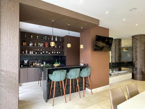 a kitchen with a bar with blue bar stools at Hotel Catena in Cochabamba