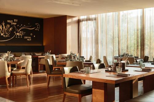 un restaurant avec des tables, des chaises et un tableau noir sur le mur dans l'établissement Renaissance Beijing Wangfujing Hotel, à Pékin