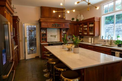 a kitchen with wooden cabinets and a large island with bar stools at Inn at Rose Hall in Eureka Springs