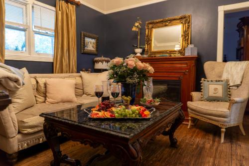 a living room with a table with fruits and wine glasses at Inn at Rose Hall in Eureka Springs