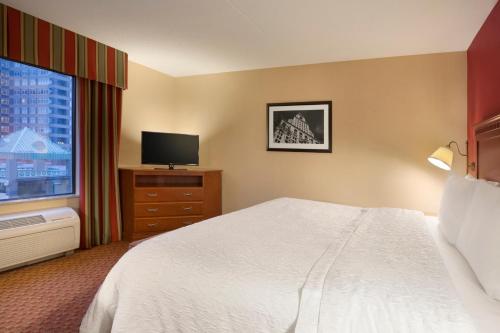 a hotel room with a bed and a television at Hampton Inn & Suites East Hartford in East Hartford