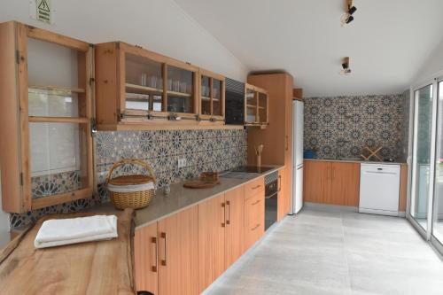 cocina con armarios de madera y encimera en Vale dos Ilhéus, en Machico