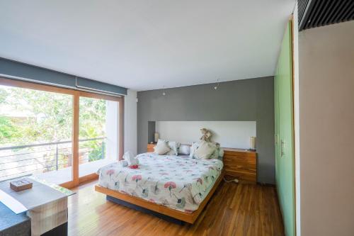 a bedroom with a bed and a large window at Villa Athena in Seminyak