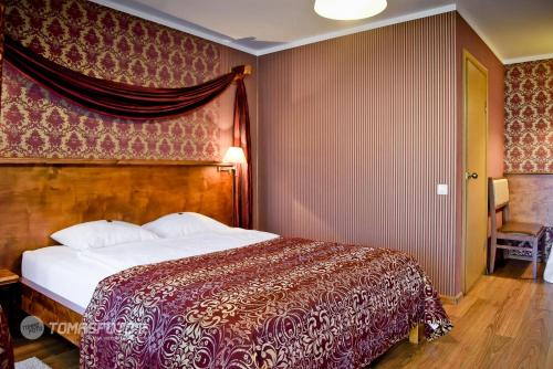 - une chambre dotée d'un lit avec une couverture rouge et blanche dans l'établissement Motelis SMAKŲ SMAKAS, à Šiauliai