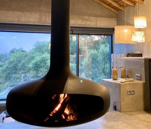 a fireplace in a room with a large window at Vigias -Eternal Landscapes in Marvão