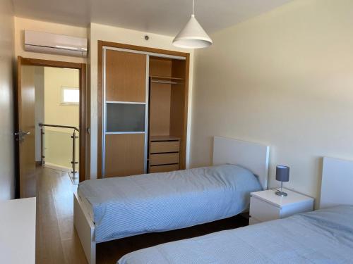 - une chambre avec 2 lits et un placard dans l'établissement Zion guest house, à Almada