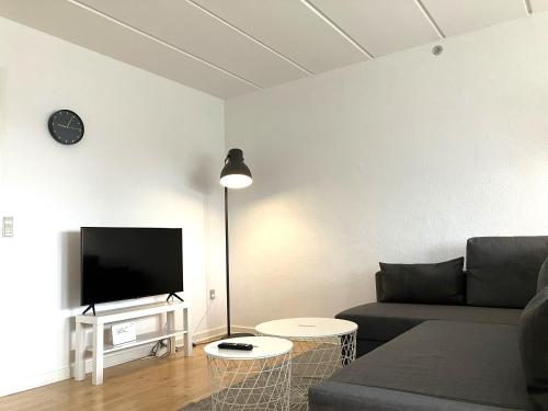 uma sala de estar com um sofá e uma televisão de ecrã plano em Tow-Bedroom Apartment Located In The Beautiful City Of Fredericia em Fredericia