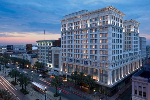 un grand bâtiment blanc sur une rue de la ville la nuit dans l'établissement The Ritz-Carlton, New Orleans, à La Nouvelle-Orléans