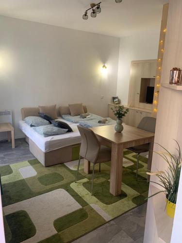 una camera con letto e tavolo e sedie di Infinity Apartman a Esztergom