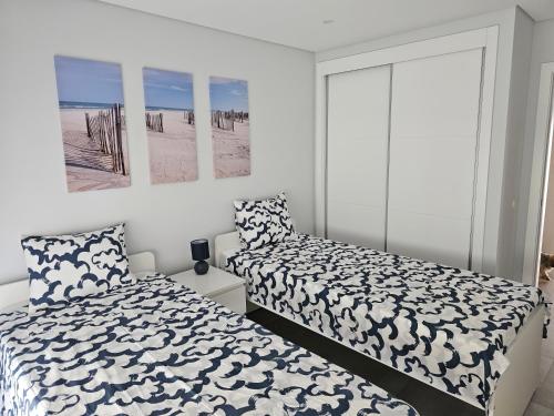 1 dormitorio con 2 camas y una foto de la playa en Apartment Dona Vitória - Monte Gordo Beach, en Monte Gordo