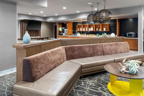 uma sala de estar com um sofá e um bar em SpringHill Suites by Marriott Baton Rouge South em Baton Rouge