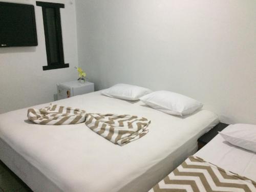 um quarto com duas camas com um cobertor em Solar dos Anjos em Arraial do Cabo